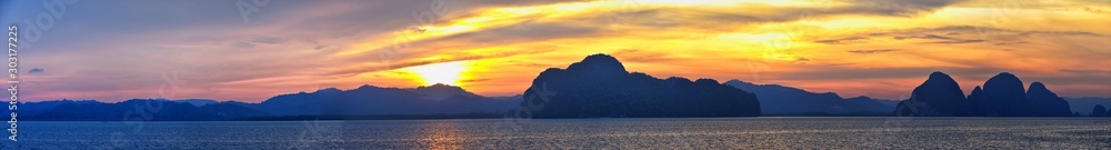 Islands Sunset, Ocean panorama views near Phuket with deep Red, Orange, Purple and Blue, mountains, twilight in Thailand. Including Phi Phi, Ko Rang Yai, Ko Li Pe and other islands. Asia. - obrazy, fototapety, plakaty 
