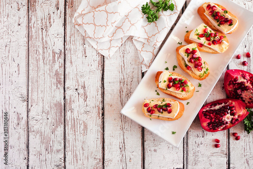 Fotografía Holiday crostini appetizers with brie cheese, pomegranates and parsley