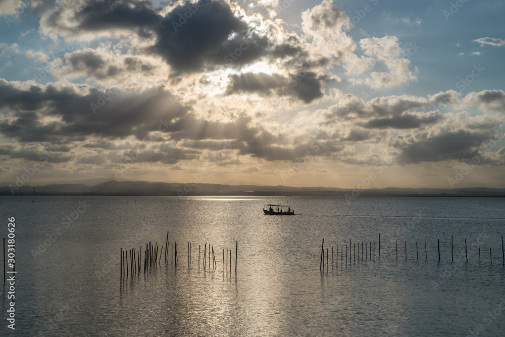  sunset in La Albufera with god light and boat silhouette