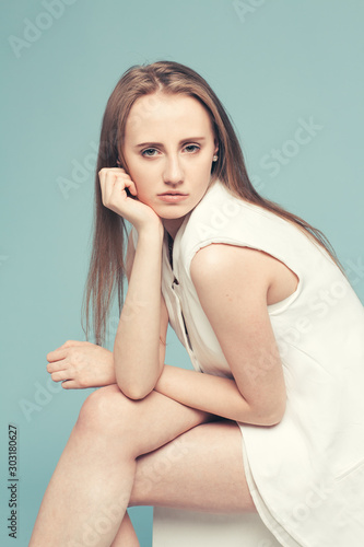 portrait of a beautiful young girl with long hair on a blue background