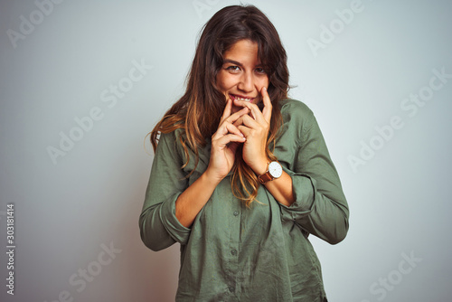 Schilderij op canvas Young beautiful woman wearing green shirt standing over grey isolated background