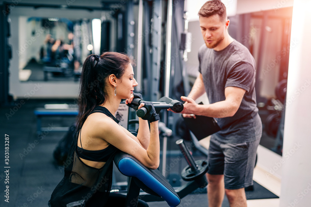 Fit woman working out with trainer at the gym. Athlete and beauty doing workout. Health life sport concept. Fit woman working out with trainer at the gym. Athlete and beauty doing workout. Health life sport concept.