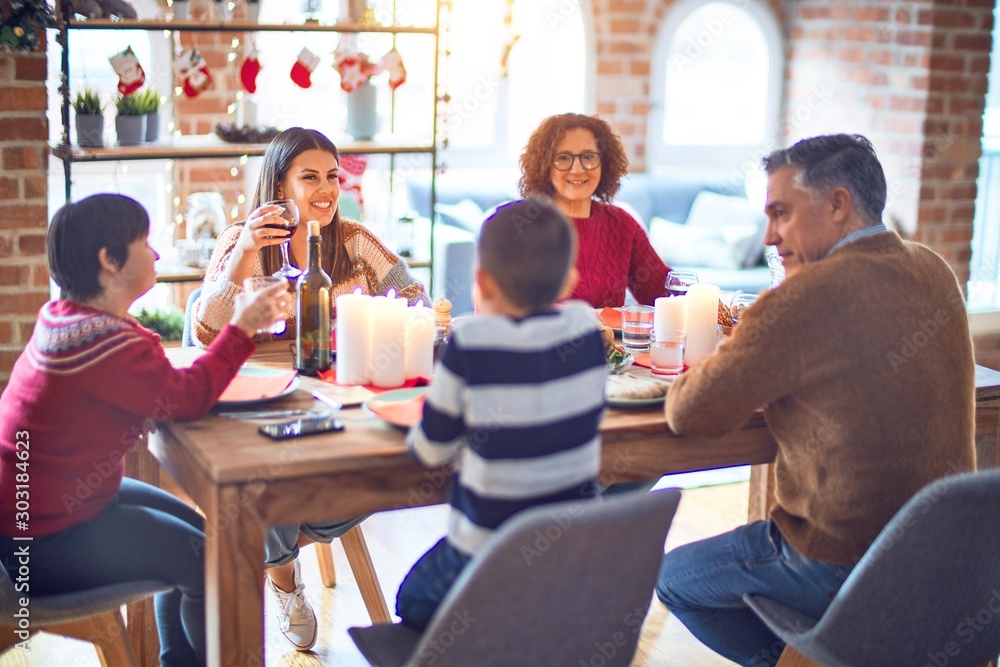 Fototapeta premium Beautiful family smiling happy and confident. Eating roasted turkey celebrating christmas at home