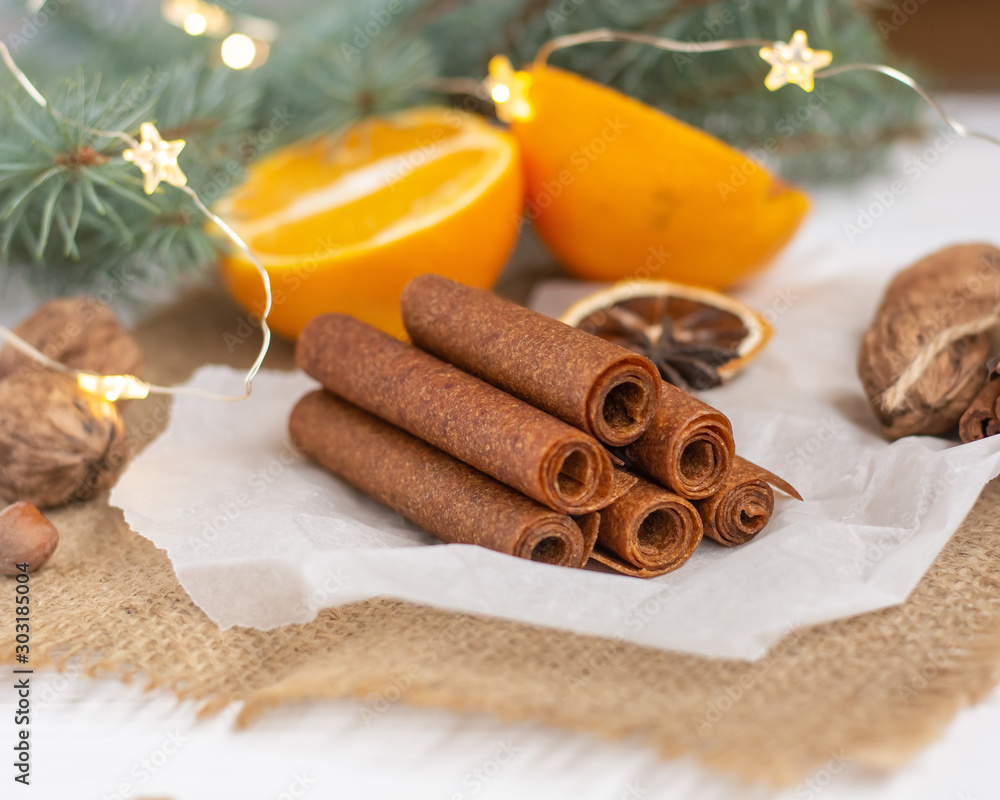 Fruit leather on parchment paper, burlap and a white board. Sprigs of spruce, garland, oranges, nuts in the background Fruit leather on parchment paper, burlap and a white board. Sprigs of spruce, garland, oranges, nuts in the background