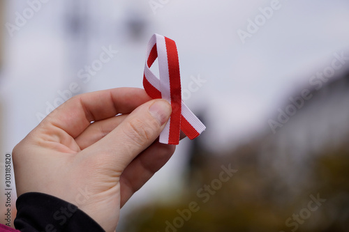 hand with red and white ribbon on background. Flag background national holiday country november celebration.1 of May, November 11, flag or independence or labor day. Government holiday in poland.