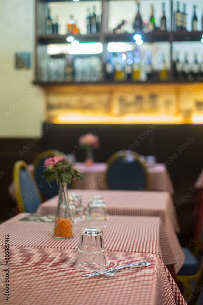  Close-up of a glass on checkered tablecloth in an Italian restaurant