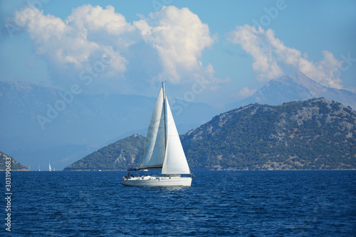 Lonely sailing yacht with a white sail