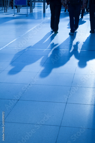 Large group of business people walking, blue toned image