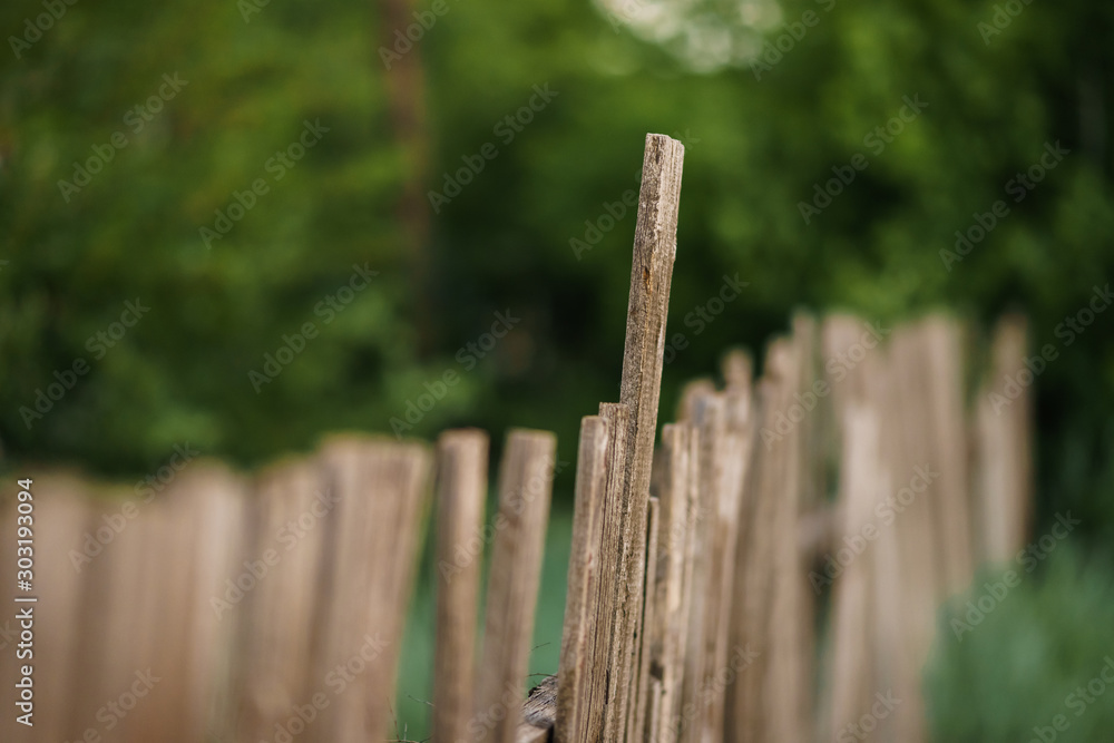 Old rural wooden fence. Fencing made of natural boards of different sizes
