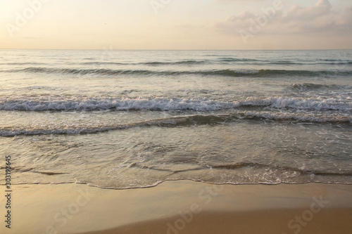 Front view of sea waves reaching the sand 
