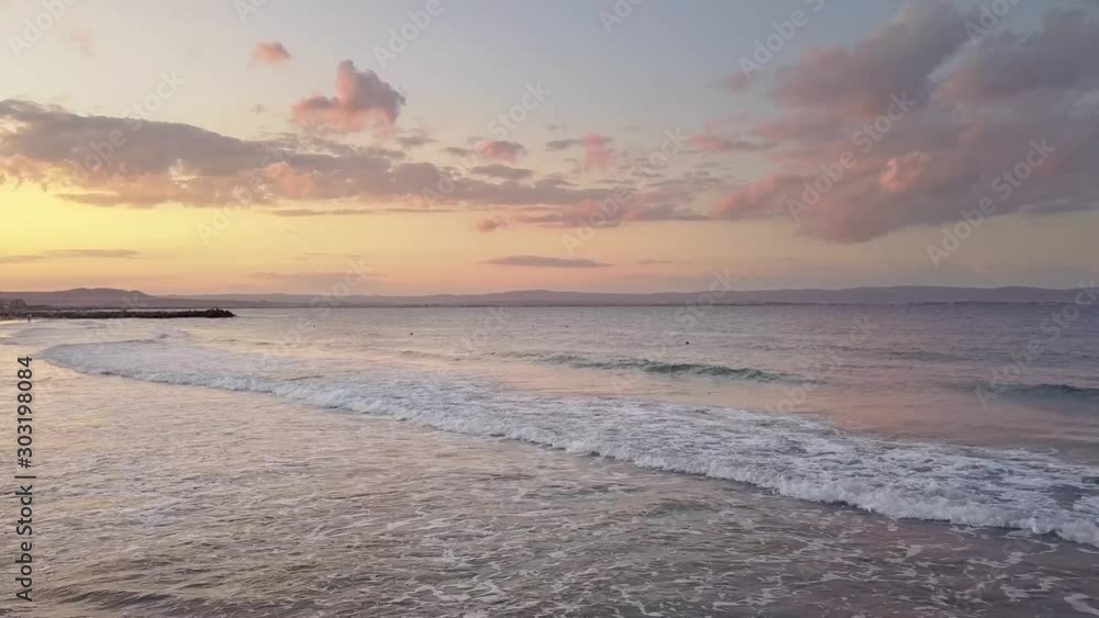 Aerial view of a sea surface with blue water waves under sunset sky. Aerial view of a sea surface with blue water waves under sunset sky.