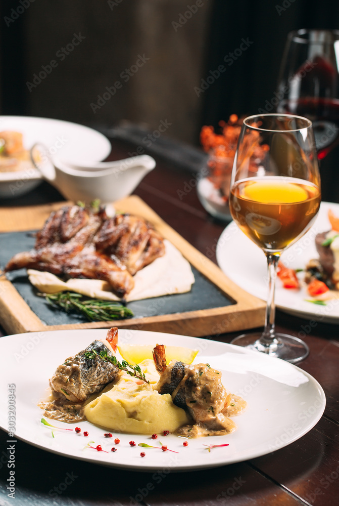Grilled partridge, sea bass, Tartarus. Different dishes on the table in the restaurant. Grilled partridge, sea bass, Tartarus. Different dishes on the table in the restaurant.