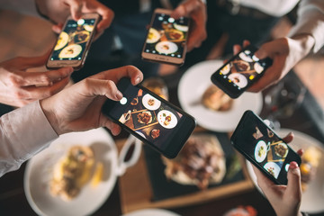 Group of friends going out and taking a photo of food together with mobile phone