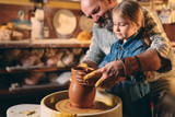 Pottery workshop. Grandpa teaches granddaughter pottery. Clay modeling
