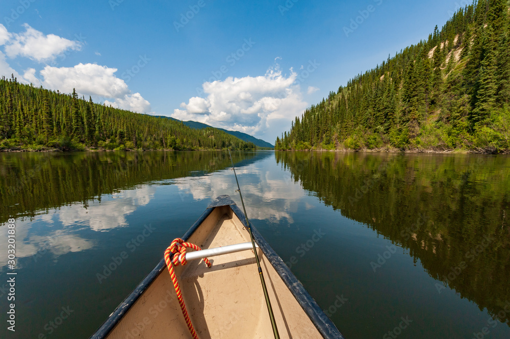 Fishing from canoe on Teslin river in Yukon, Canada