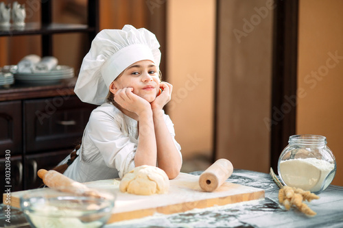 girl kid are preparing the dough in the kitchen.