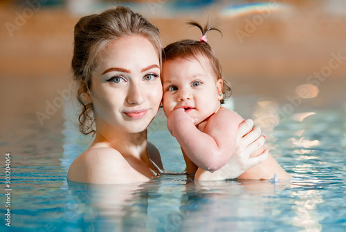 Mom and baby swim in the pool. © davit85