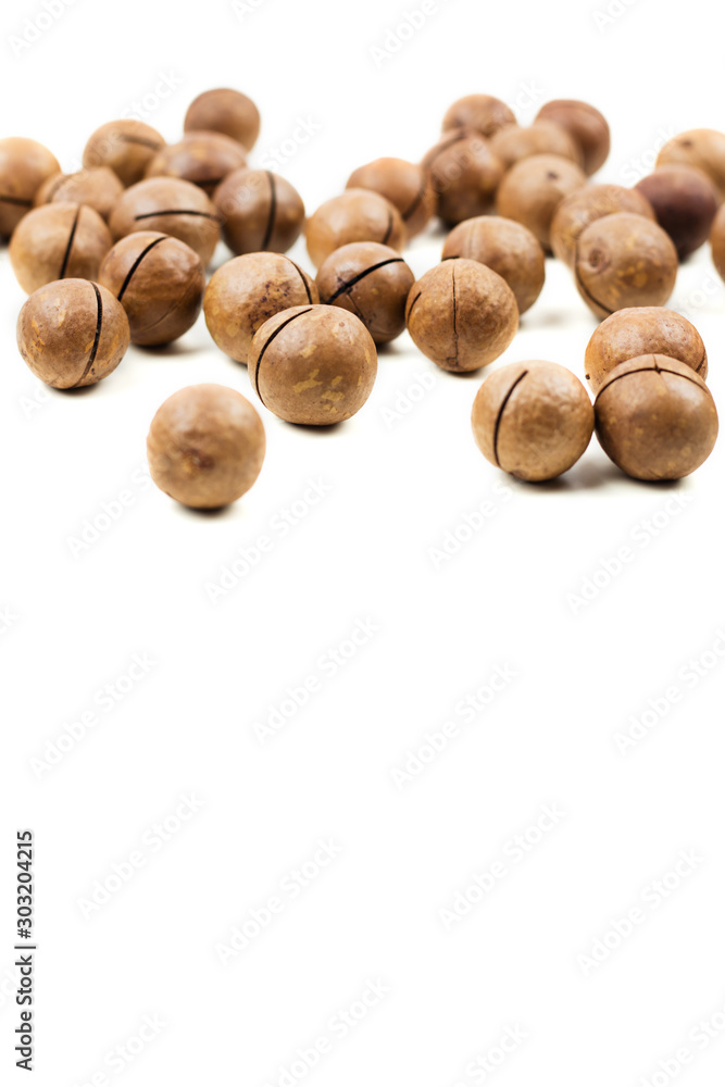 Raw not peeled whole macadamia nuts isolated on white Raw not peeled whole macadamia nuts isolated on white