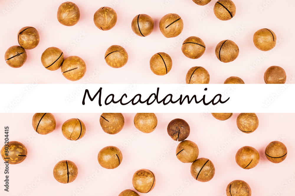 Fototapeta premium Raw not peeled macadamia nuts on pink background.