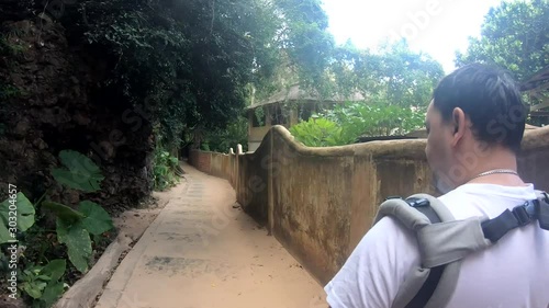 Caucasian Man Carrying Toddler in Baby Carrier While Hiking in tropics photo