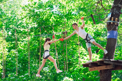 Photography couple spend their leisure time in a ropes course
