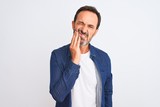 Middle age handsome man wearing blue denim shirt standing over isolated white background touching mouth with hand with painful expression because of toothache or dental illness on teeth