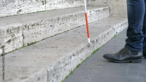 blindness, autonomy,independence.Blind person climbig stairs with walking stick photo