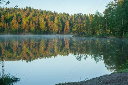 Fog on mirror clear lake at sunrise