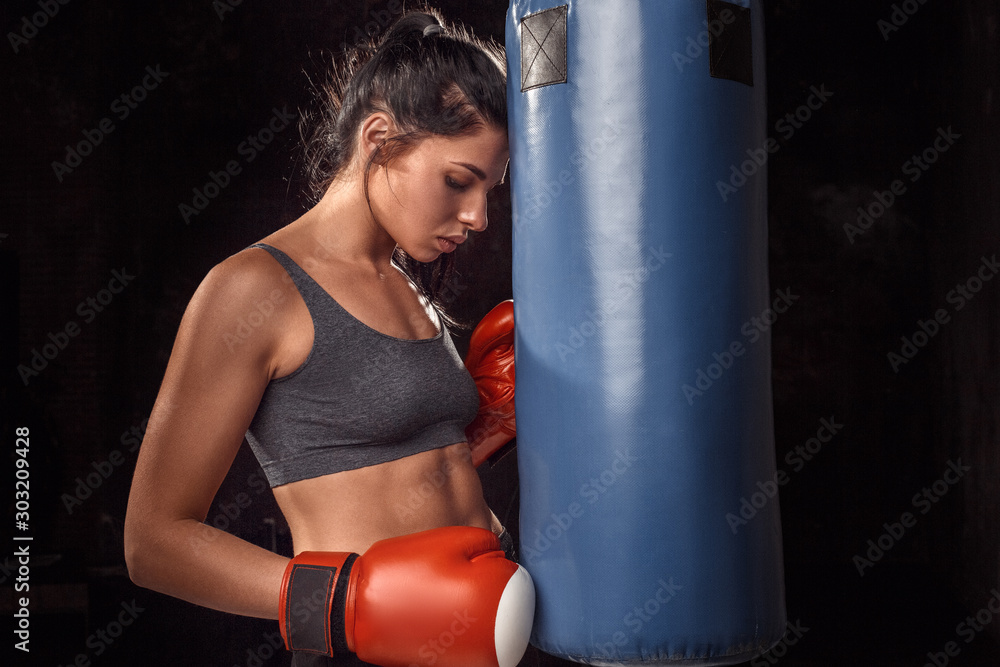 Boxing. Woman boxer in gloves exercise with punching bag touching sensual