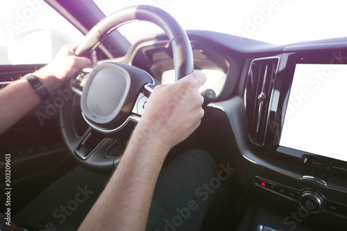 Man driving a car. Success in motion. Handsome young man driving a car. A man holds the steering wheel of a car.