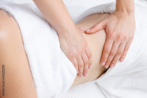 Massage Therapist Massaging a Womens Stomach. Massage and body care. Spa body massage woman hands treatment. © Elena