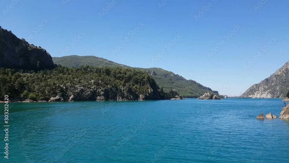 View from a boat sailing on a lake among mountain cliffs in the area of the Oimapinar dam. Landscape of Green canyon, Manavgat, Antalya, Turkey View from a boat sailing on a lake among mountain cliffs in the area of the Oimapinar dam. Landscape of Green canyon, Manavgat, Antalya, Turkey