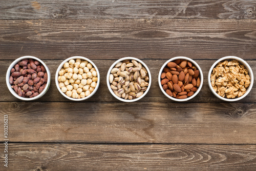 Different kinds of nuts in ceramic bowls.