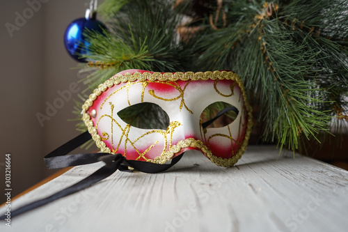  Christmas mask on a white Board on the background of a pine branch