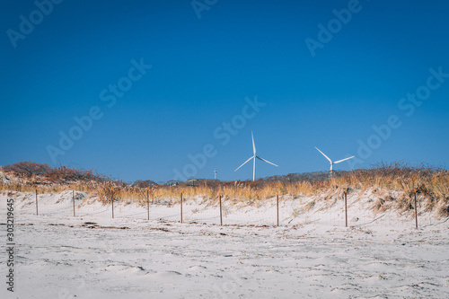 Windmill turbine on fenced beach in gloucester photo