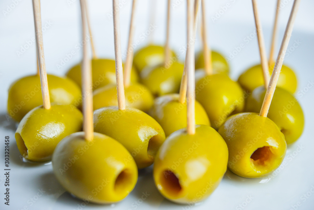 Olive con stuzzicadenti su piatto bianco, aperitivo Olive con stuzzicadenti su piatto bianco, aperitivo