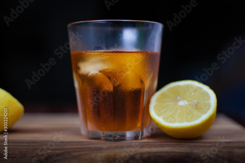a glass of brandy with some lemon and ice