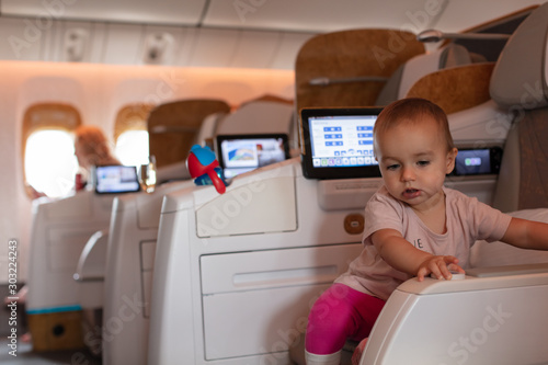Toddler girl discovering her business class seat