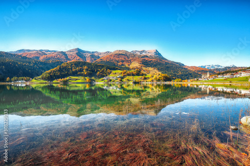 Bright autumn view of San Valentino village and Muta lake  Haidersee 