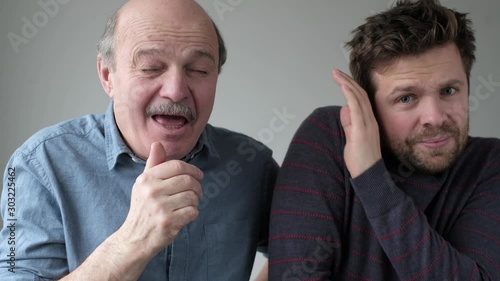 Man holding sneezing with closed eyes. His coworker try to hide from microbes. photo