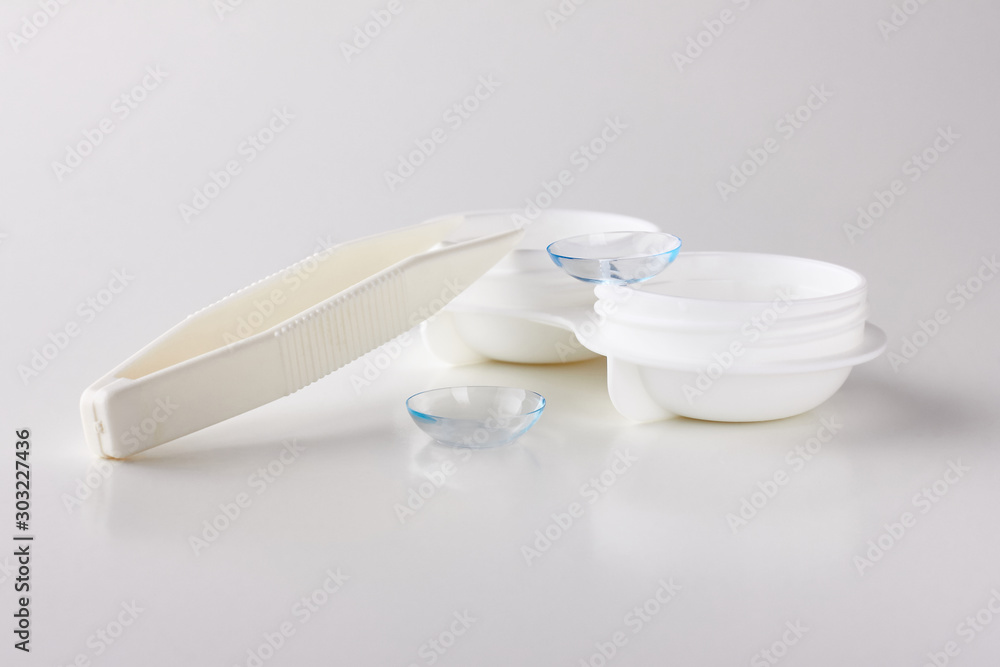 Contact lenses, case and tweezers on white background. Eye health and care, eyesight and vision, ophthalmology and optometry Contact lenses, case and tweezers on white background. Eye health and care, eyesight and vision, ophthalmology and optometry