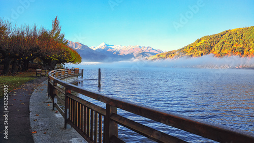 Spectacular autumn view of lake and trees in city park of Sell Am See