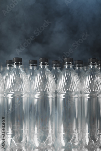 empty plastic bottles on black background with smoke  pollution concept