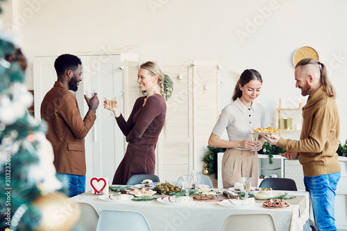 Photography Side view portrait of elegant young people enjoying Christmas party and smiling