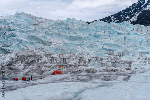 Mendenhall glacier in Juneau, Alaska. Hiking camp on the ice. Red tent is set on the snow for an expedition and ice climbing.