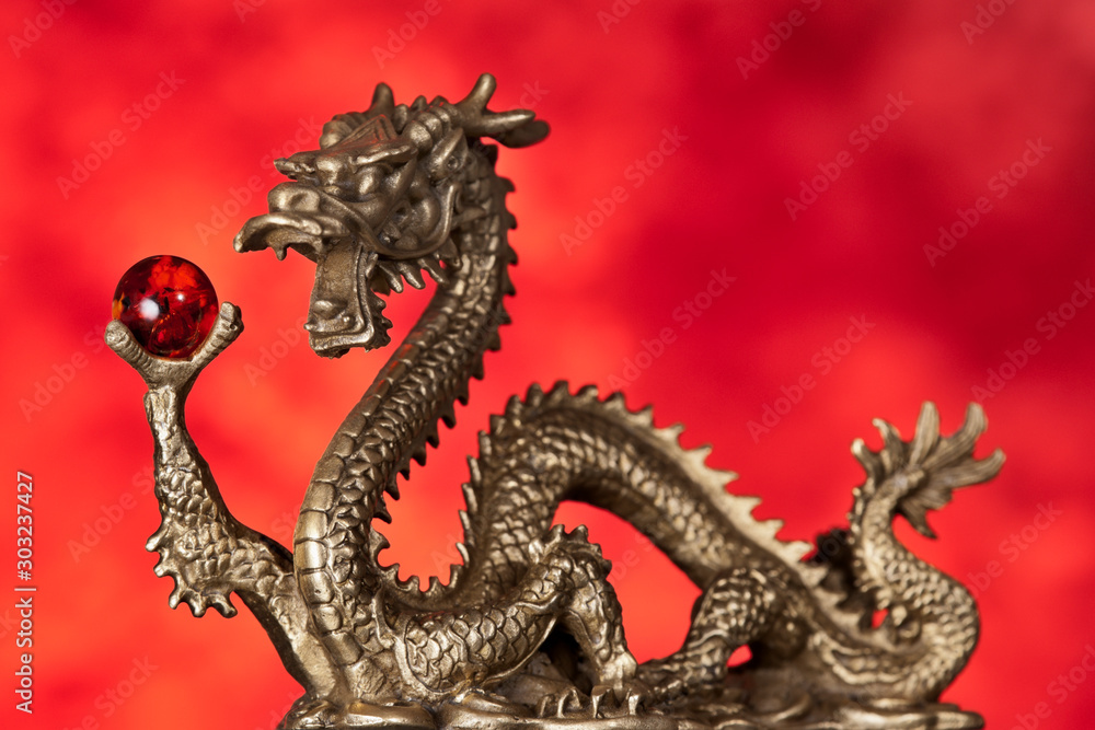 A small statue of a Chinese Dragon holding an orb