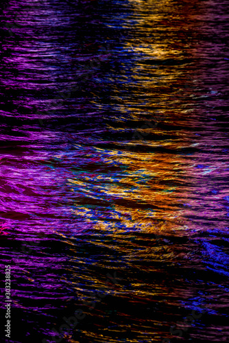 Abstract, colorful reflections of city lights at night on Victoria Harbor, Hong Kong, China; Background or spot color depicting nightlife, energy, electricity, development or technology