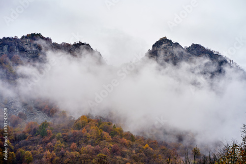 two rocks covered by clouds and a fog in Italian Piemonte