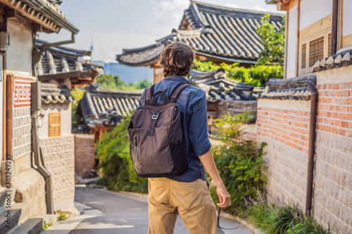 Photography Young man tourist in Bukchon Hanok Village is one of the famous place for Korean traditional houses have been preserved