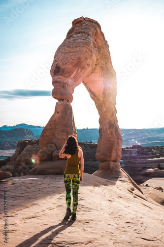 Obraz na płótnie Girl in yoga pants standing in front of delicate arch